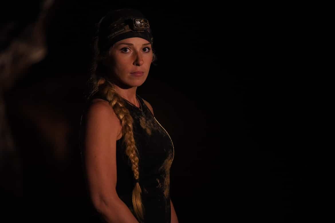 Woman with braided hair and headband against a dark background