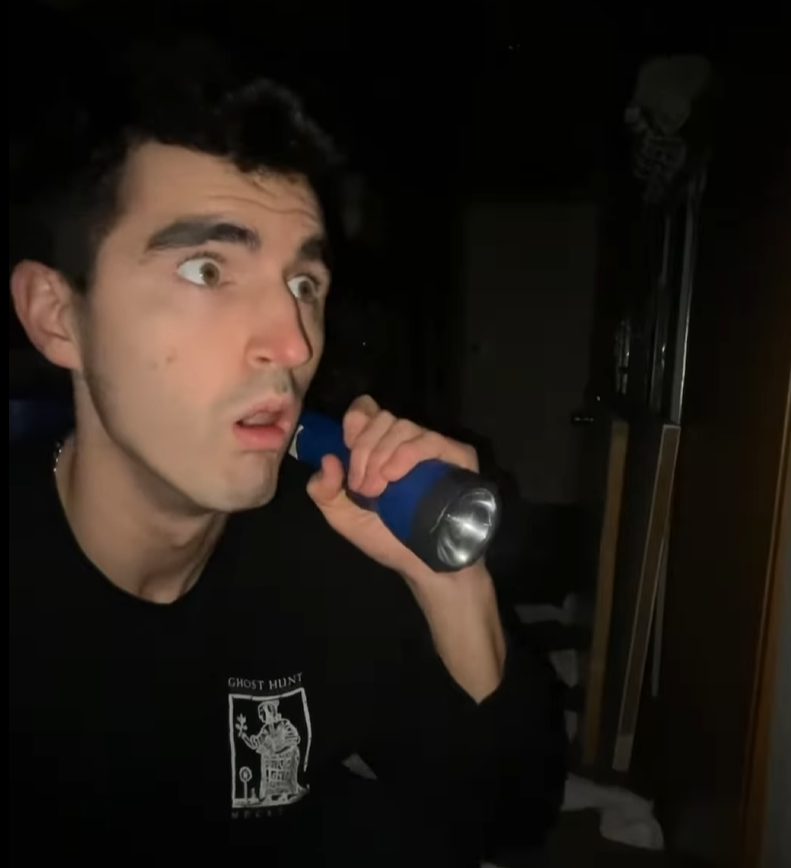 Person holding a flashlight in a dark room